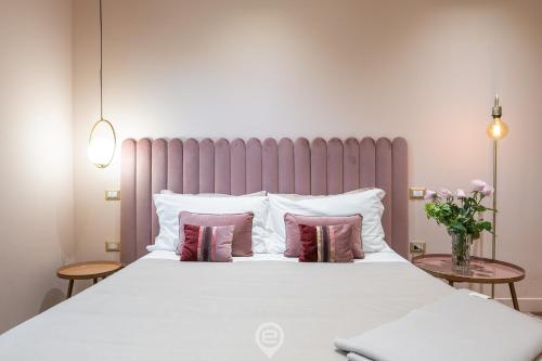 a bedroom with a large white bed with pillows at Biora Hospitality in Serri