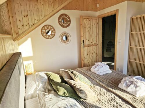 a bedroom with a bed with towels on it at Czôrny Dąb - nowoczesny dom wakacyjny na Kaszubach, jacuzzi, sauna, bilard in Garcz