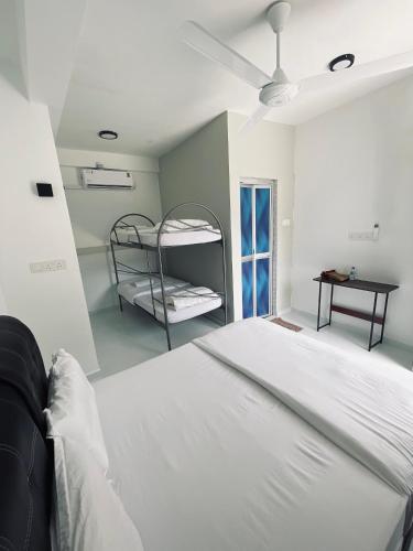 a white bedroom with a bed and bunk beds at CasaView Beach in Paka