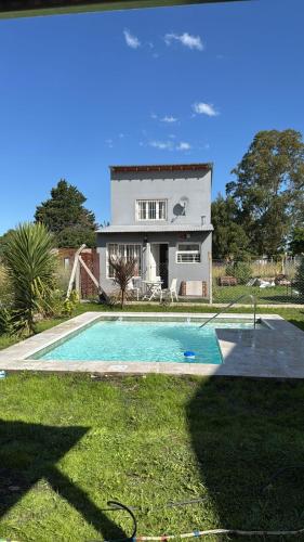 a house with a swimming pool in front of a house at Complejo Santa Ana Miramar Buenos Aires in Miramar