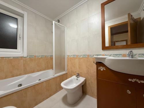 a bathroom with a sink and a toilet and a mirror at Oktheway O Burgo in El Burgo