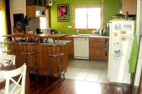 - une cuisine avec des murs verts et un réfrigérateur blanc dans l'établissement Maison et Plage de Sable Fin, à l'Île-Tudy