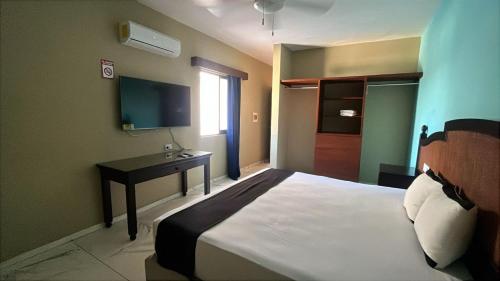 a bedroom with a bed and a desk in it at Hotel Yukon in Playa del Carmen