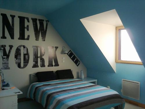 une chambre avec un lit dans une pièce bleue dans l'établissement Maison et Plage de Sable Fin, à l'Île-Tudy