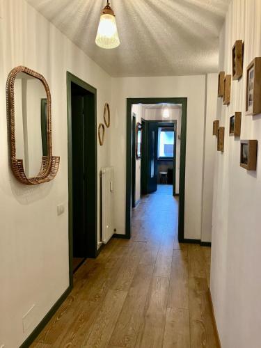 a hallway with a mirror on the wall and a hallway with a hallway at Beautiful family apartment with pool in Carisolo