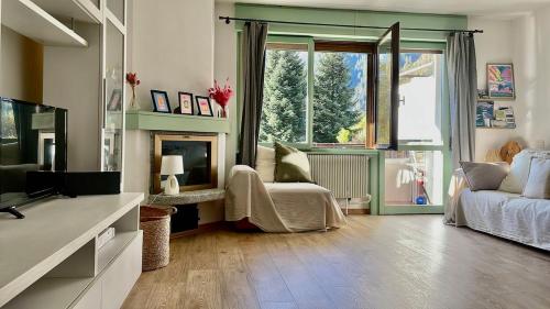 a living room with a fireplace and a couch at Beautiful family apartment with pool in Carisolo