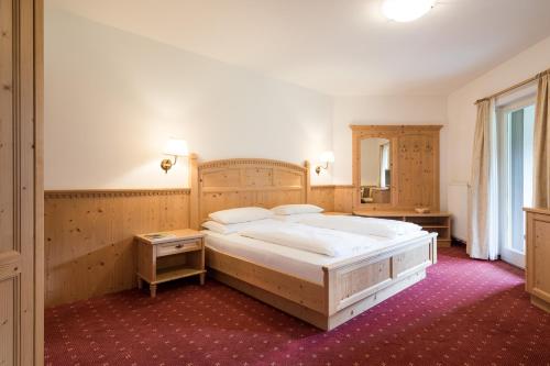 a large bedroom with a large bed and a mirror at Tonzhaus Hotel in Senales