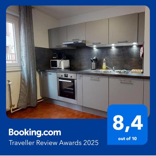 une cuisine avec des armoires blanches et un four à plaques de cuisson dans l'établissement Les Charpentiers, à Colmar