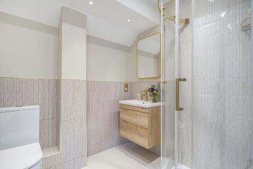 Un baño con lavabo, inodoro y espejo. en The Pink House, Salcombe, with Free Parking, en Salcombe