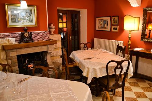 a dining room with two tables and a fireplace at ColmarinoHouse in Rotorscio