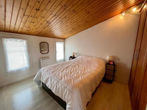 une chambre avec un lit et un plafond en bois dans l'établissement La Salamandre - Situé en plein coeur de ville et proche des thermes, à Rochefort