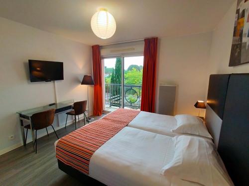 a hotel room with a bed and a desk and a window at Adonis La Baule in La Baule