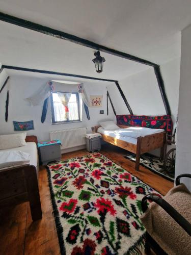 a bedroom with a bed and a rug on the floor at Complex Tradițional Casa din Vale Breb in Breb