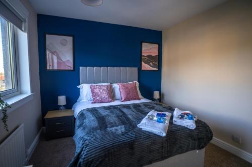 a bedroom with a bed with a blue wall at Camps Rigg Place in Livingston