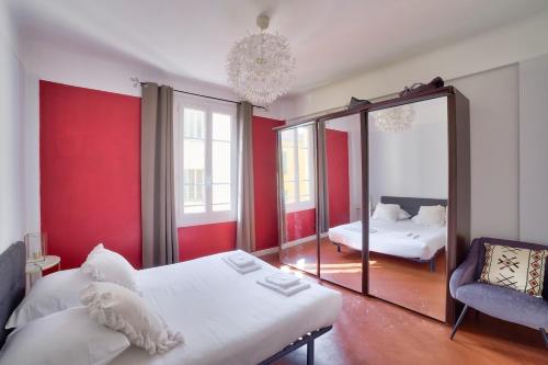 - une chambre avec des murs rouges, un miroir et un lit dans l'établissement Stunning 2BR by the Port 20min Walk to the Beach, à Nice