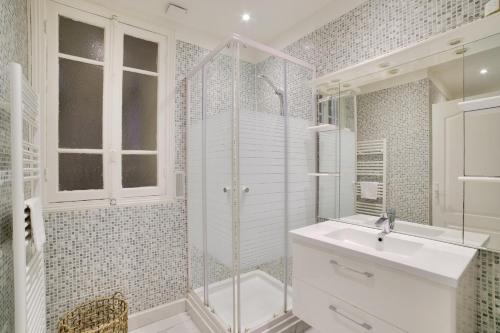 une salle de bain blanche avec un lavabo et une douche dans l'établissement Stunning 2BR by the Port 20min Walk to the Beach, à Nice