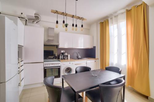 une cuisine avec une table et des chaises dans une cuisine dans l'établissement Stunning 2BR by the Port 20min Walk to the Beach, à Nice