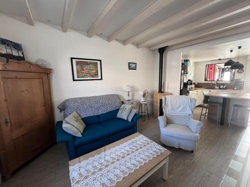 un salon avec un canapé bleu et une chaise dans l'établissement La Brémontine, à Parentis-en-Born