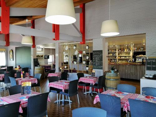 un restaurant avec des tables, des chaises et un comptoir dans l'établissement Camping Le Soleil des Landes, à Lit-et-Mixe