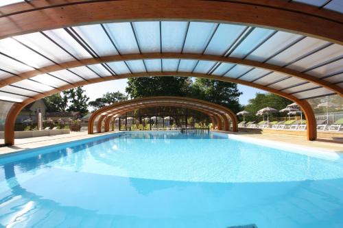 une grande piscine avec un plafond voûté dans l'établissement Camping Le Soleil des Landes, à Lit-et-Mixe