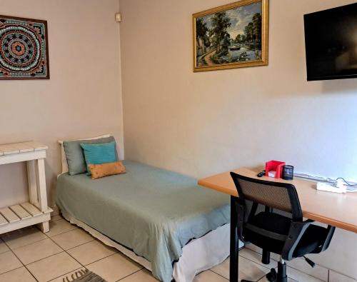 a room with a desk and a bed and a desk and a desk at 122 on Krantzview previously BizAfrika Guest Lodge in Kloof