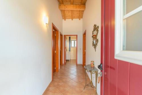 a hallway with a red door and a table at Herdade Vale de Gaios in Odemira