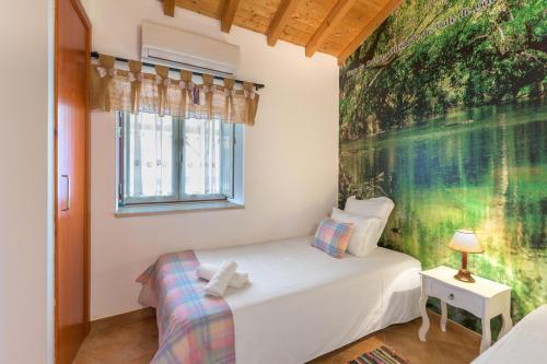 a small bedroom with a white bed and a window at Herdade Vale de Gaios in Odemira