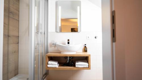 a bathroom with a sink and a mirror at Das Haus am See in Sinzheim