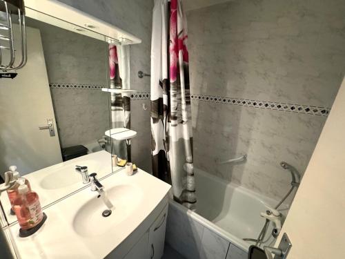une salle de bain avec un lavabo et une baignoire dans l'établissement Appartement - Cap d'Agde, au Cap d'Agde