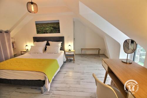 a bedroom with a bed and a table and a desk at La boucaliniere in Plurien