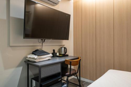 a room with a desk with a television on a wall at Mnlucky Hotel in Seoul