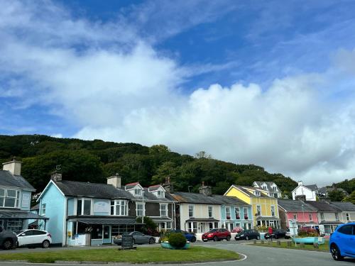 a row of houses in front of a mountain at Apartment Porthmadog harbourside fantastic estuary views Great spot with parking in Porthmadog