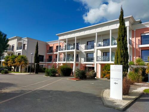 an apartment building with a sign in a parking lot at Adonis La Baule in La Baule