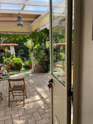 a door to a patio with a table and a chair at Araucaria in Tropea
