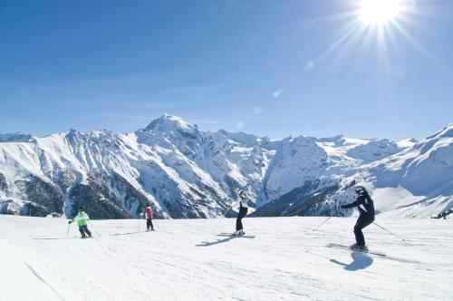 a group of people skiing down a snow covered mountain at Hotel Bella Vista in Trafoi