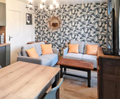 salon z kanapą i stołem w obiekcie Appartement cosy à Saint-Vaast-la-Hougue - 55 m² avec jardin w mieście Saint-Vaast-la-Hougue