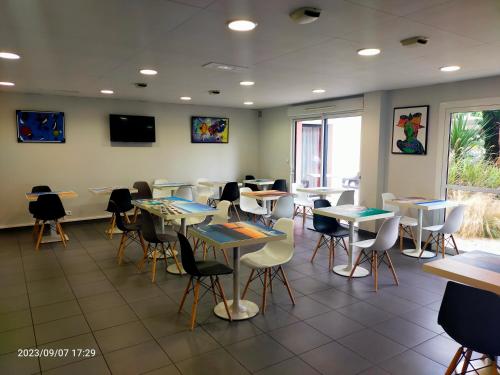 a classroom with tables and chairs in a room at Adonis La Baule in La Baule