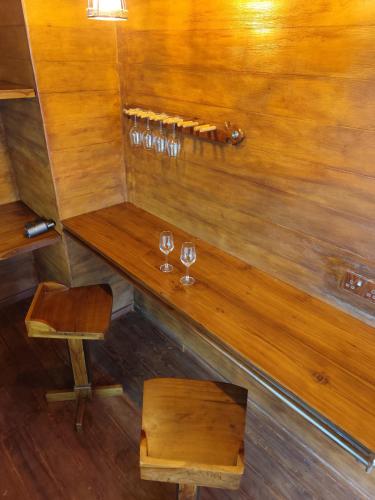 a wooden table with wine glasses on a wall at Miracle view Ella in Ella