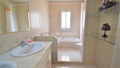 un bagno con lavandino, vasca e WC di MAISON ENTIERE AVEC PISCINE, WIFI, GRAND SOLARIUM ET TERRAIN ARBORE a Orihuela