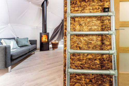 a room with a fireplace and a wall of hay at Woodland dome in Thornbury