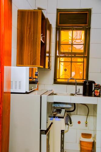 eine Küche mit Spüle und Fenster in der Unterkunft Elite Haven in Masaka