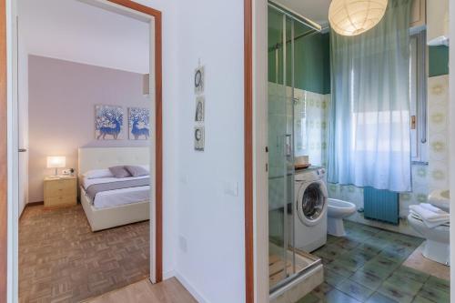 a bathroom with a toilet sink and a washing machine at Roberta s Home in Perledo
