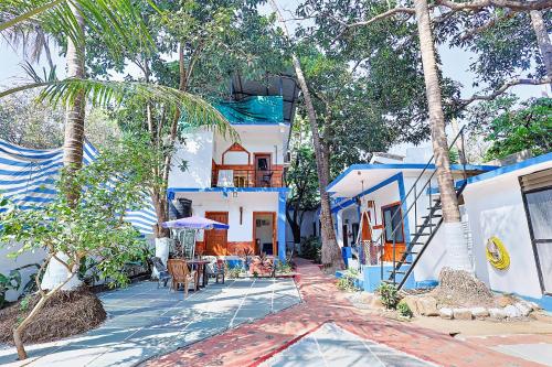 a blue and white house with a table and chairs at FabExpress Horizon Hideaway - Nr Anjuna Beach in Anjuna