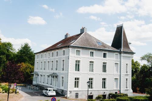a large white building with a pointed roof at Hôtel Château de la Marlière in Fourmies
