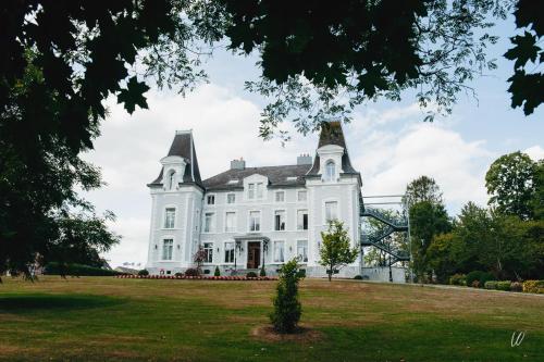 a large white house with a large yard at Hôtel Château de la Marlière in Fourmies