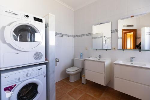 a bathroom with a washing machine and a sink at Villa Diana in Benitachell