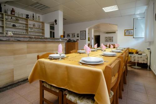 a row of tables in a room with yellow tablecloths at Pension Silvia in Međugorje