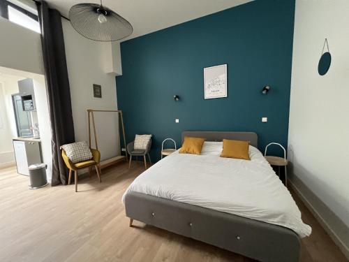 a bedroom with a bed with a blue wall at Le Calais Wilson 3, Studio 2P in Calais
