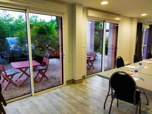 a room with sliding glass doors with a table and chairs at Adonis La Baule in La Baule