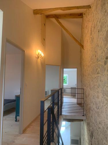 Cette chambre est dotée d'un escalier et d'un mur en pierre. dans l'établissement Lestable du pin, à Le Pin